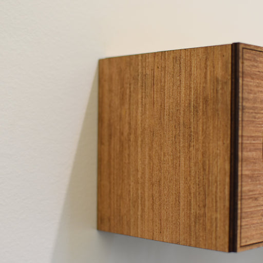 Wooden wall shelf with decorative cutout on a plain wall