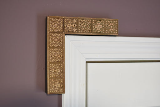Decorative corbel with intricate gold frame on a purple wall